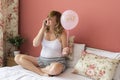 A smiling pregnant woman sitting in bed with pink balloon Ã¢â¬ÅitÃ¢â¬â¢s a girlÃ¢â¬Â talking over smart phone Royalty Free Stock Photo